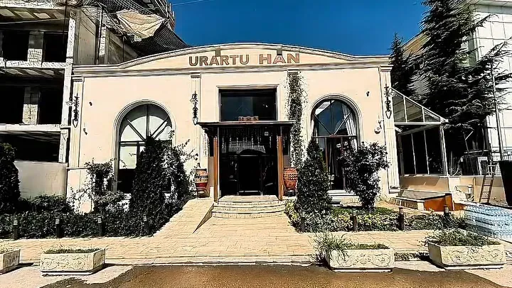 Urartu Han yazısı taşıyan beyaz cephe, kemerli pencereler ve ana giriş.