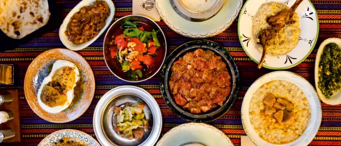 Üstten çekilmiş Han Sofra: içli köfte, salata, Van güveci, siyabolu kavurma, beğendili kuzu pirzola ve keledoş.